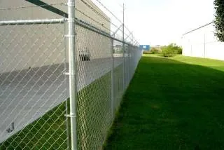 Malla ciclónica con poste bayoneta y alambre de púas instalada en terreno